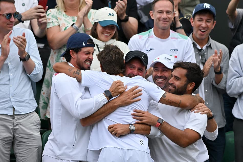 O italiano Flavio Cobolli é abraçado pelo pai, Stefano, e por sua equipe após vitória sobre o croata Marin Cilic (Foto: Glyn KIRK / AFP)