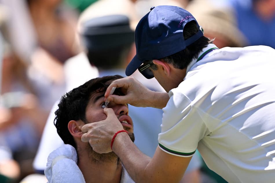 O espanhol Carlos Alcaraz recebe atendimento médico na semifinal de Wimbledon (Foto: Glyn KIRK / AFP)