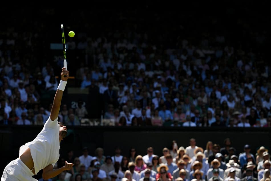 O espanhol Carlos Alcaraz saca na partida contra o americano Taylor Fritz (Foto: Glyn KIRK / AFP)
