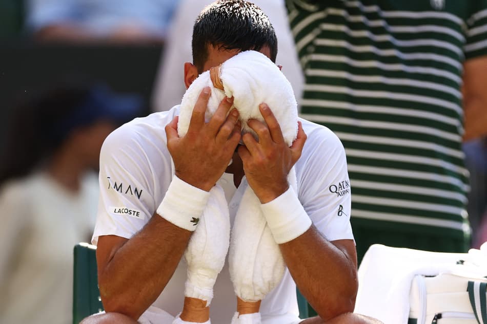 Novak Djokovic tenta aliviar o calor na partida contra o líder do ranking, Jannik Sinner (Foto: HENRY NICHOLLS / AFP)