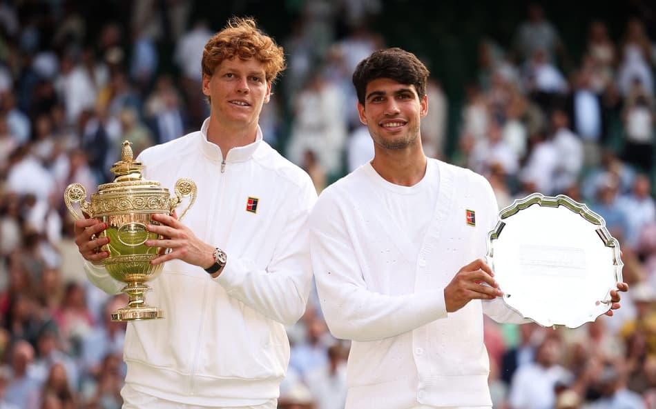 O italiano Jannik Sinner e o espanhol Carlos Alcaraz com os troféus de Wimbledon (Foto: HENRY NICHOLLS / AFP)