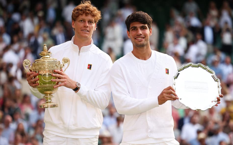O italiano Jannik Sinner e o espanhol Carlos Alcaraz com os troféus de Wimbledon (Foto: HENRY NICHOLLS / AFP)