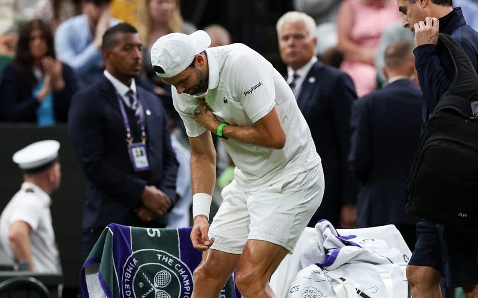 Grigor Dimitrov dente dores antes de abandonar a partida contra Jannik Sinner em Wimbledon (foto: Adrian Dennis / AFP)