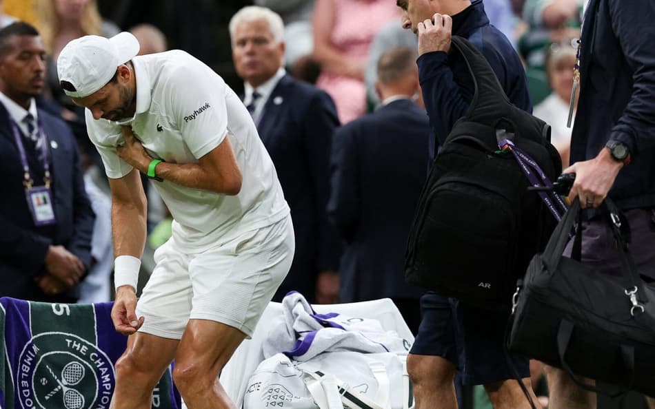 Grigor Dimitrov dente dores antes de abandonar a partida contra Jannik Sinner em Wimbledon (foto: Adrian Dennis / AFP)