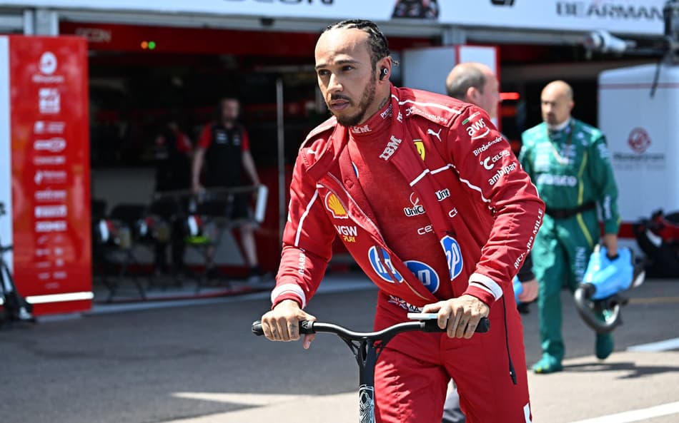 Ferrari's British driver Lewis Hamilton rides a scooter in the pit lane ahead of the Formula One Monaco Grand Prix at the Circuit de Monaco, on May 25, 2025. (Photo by Gabriel BOUYS / POOL / AFP)