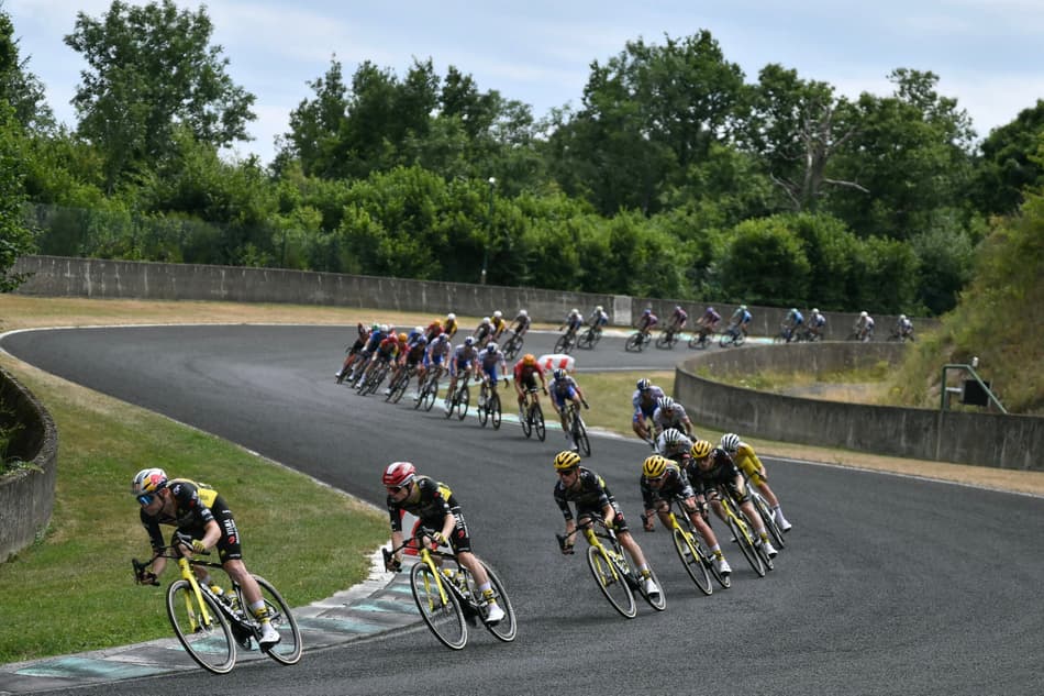Wout van Aert (esquerda) pedala com o grupo de pilotos em uma descida no Circuito Automobile de la Charade durante a 10ª etapa da Tour de France 2025 (foto: Marco BERTORELLO/AFP)