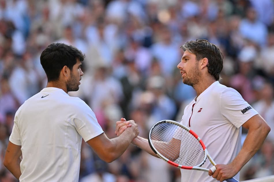 Carlos Alcaraz aperta as mãos de Cameron Norrie após vitória em Wimbledon (foto: Glyn KIRK / AFP)