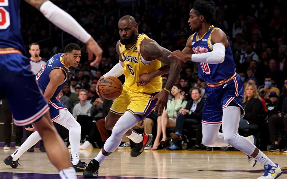 LeBron James, do Lakers, em disputa contra Jonathan Kuminga, do Warriors, pela NBA (Foto: AFP)