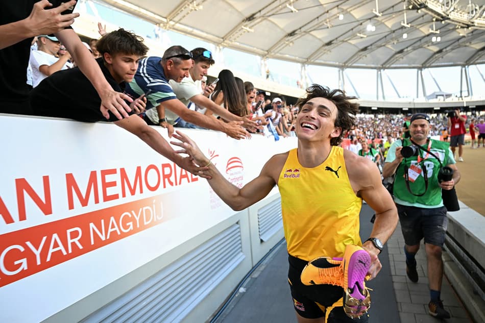 Duplantis comemora com a torcida seu novo recorde (Foto: Attila KISBENEDEK / AFP)