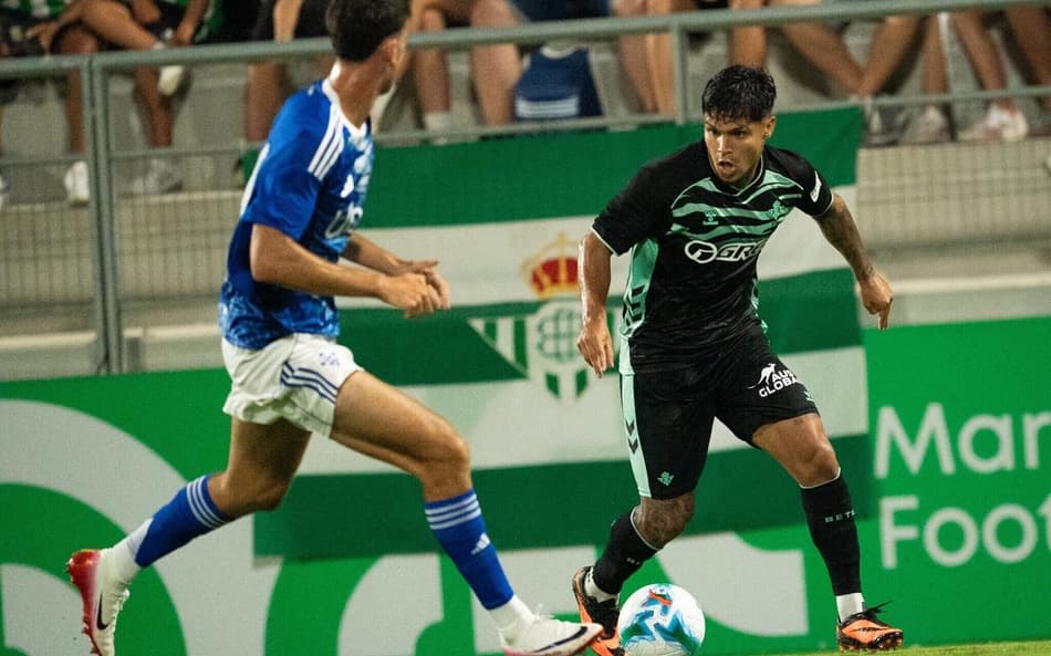 Cucho Hernández, do Betis, tenta passar pela marcação do defensor do Como