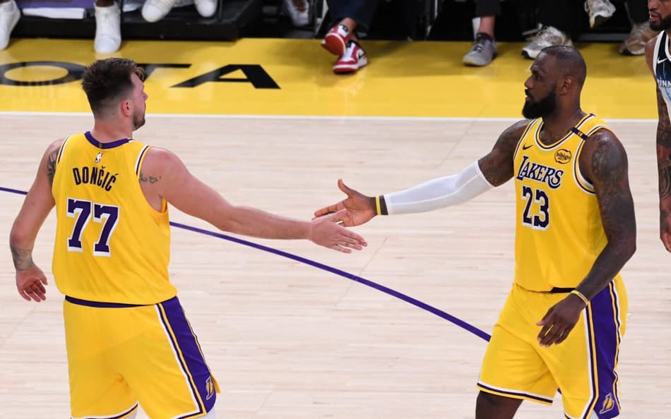 Luka Doncic e LeBron James, do Los Angeles Lakers, se cumprimentam em jogo contra o Minnesota Timberwolves pela NBA (Foto: Juan Ocampo/NBAE via Getty Images/AFP)