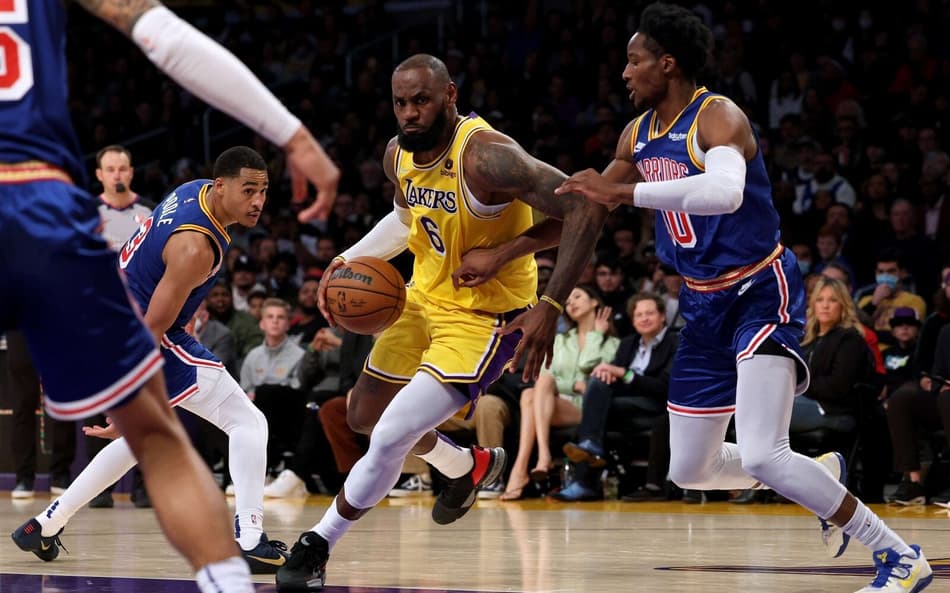LeBron James, do Lakers, em disputa contra Jonathan Kuminga, do Warriors, pela NBA (Foto: AFP)
