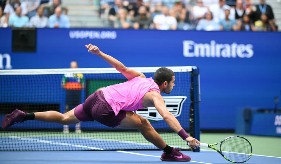 Alcaraz tenta alcançar uma bola lançada por Djokovic (Foto: ANGELA WEISS / AFP)
