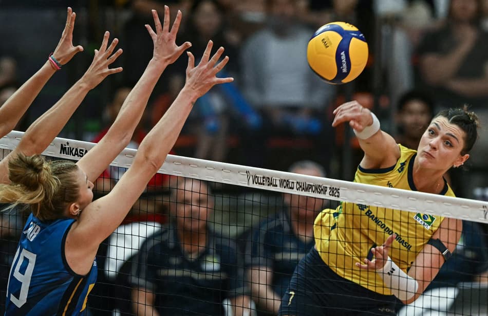 Brazil's #7 Rosamaria Montibeller (R) spikes the ball as Italy's #19 Sarah Luisa Fahr (L) attempts to block during their 2025 Women's Volleyball World Championships semi-final match in Bangkok on September 6, 2025. (Photo by Lillian SUWANRUMPHA / AFP)