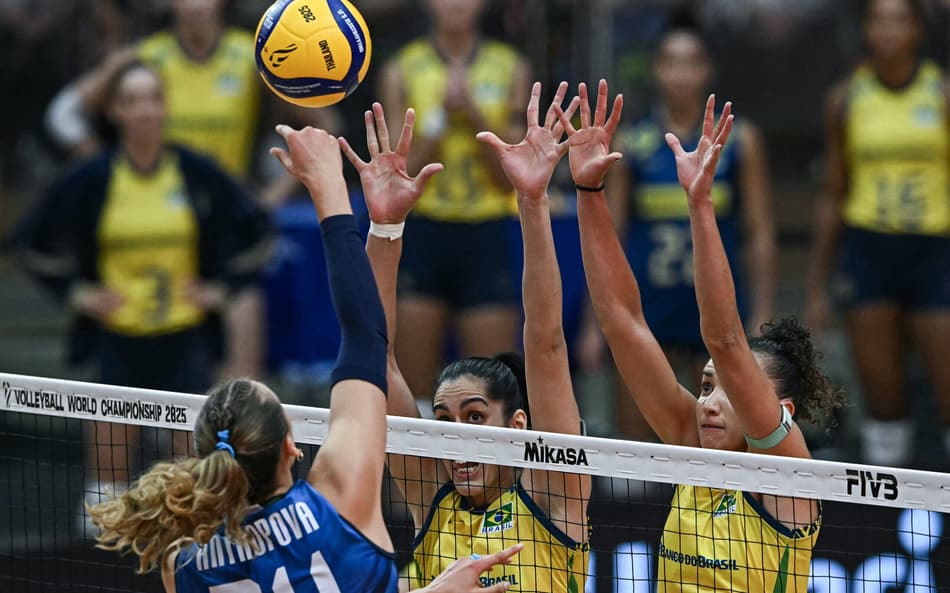 Italy's #24 Ekaterina Antropova spikes the ball as Brazil's #2 Diana Duarte Alecrim and Brazil's #10 Gabriela Braga Guimaraes attempt to block during their 2025 Women's Volleyball World Championships semi-final match in Bangkok on September 6, 2025. (Photo by Lillian SUWANRUMPHA / AFP)