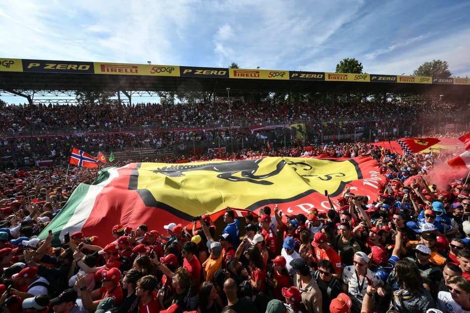 Supporters and Ferrari fans deploy a giant Ferrari flag on the track after the Italian Formula One Grand Prix at the Autodromo Nazionale Monza circuit, in Monza, northern Italy, on September 7, 2025. (Photo by Marco BERTORELLO / AFP)