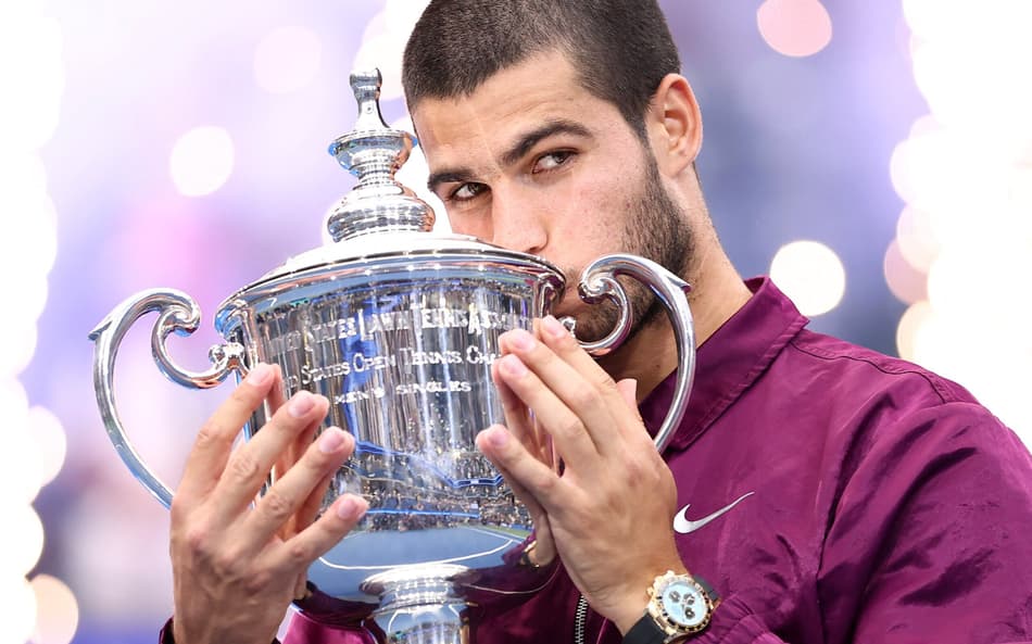 O espanhol Carlos Alcaraz beija seu segundo troféu do US Open (Foto: CHARLY TRIBALLEAU / AFP)