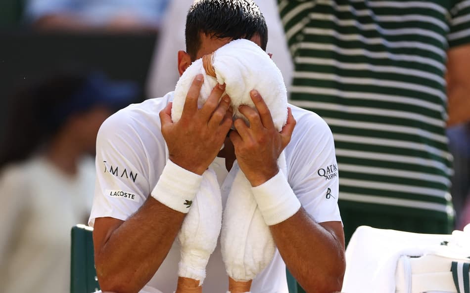 Novak Djokovic tenta aliviar o calor na partida contra o líder do ranking, Jannik Sinner (Foto: HENRY NICHOLLS / AFP)