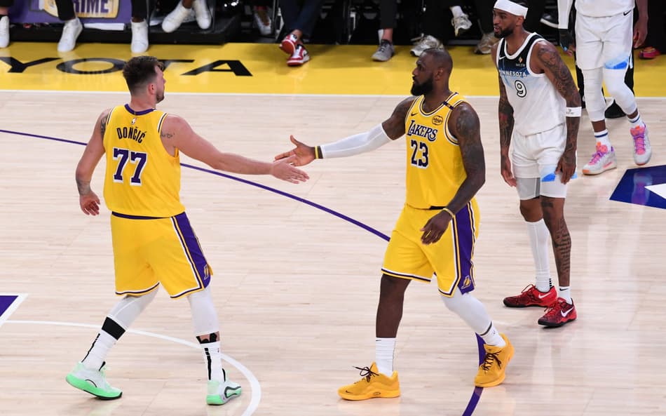Luka Doncic e LeBron James, do Los Angeles Lakers, se cumprimentam em jogo contra o Minnesota Timberwolves pela NBA (Foto: Juan Ocampo/NBAE via Getty Images/AFP)