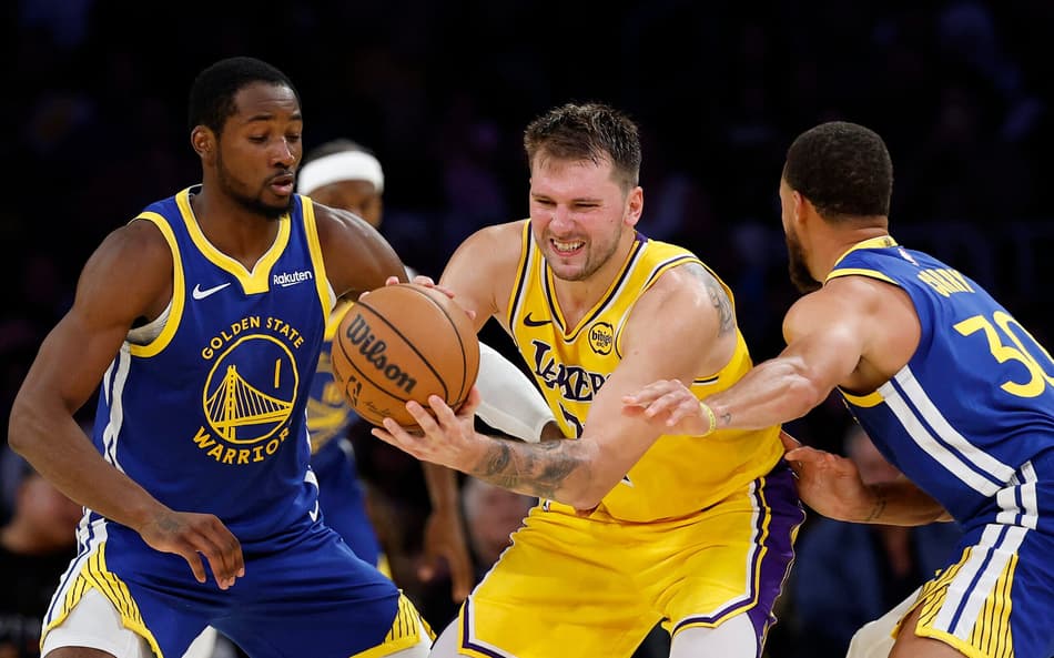 LOS ANGELES, CALIFORNIA - OCTOBER 21: Luka Doncic #77 of the Los Angeles Lakers is trapped by Jonathan Kuminga #1 and Stephen Curry #30 of the Golden State Warriors in the fourth quarter of the game at Crypto.com Arena on October 21, 2025 in Los Angeles, California. NOTE TO USER: User expressly acknowledges and agrees that, by downloading and or using this photograph, user is consenting to the terms and conditions of the Getty Images License Agreement. Harry How/Getty Images/AFP (Photo by Harry How / GETTY IMAGES NORTH AMERICA / Getty Images via AFP)