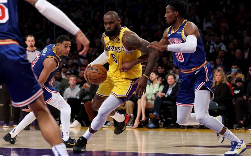 LeBron James, do Lakers, em disputa contra Jonathan Kuminga, do Warriors, pela NBA (Foto: AFP)