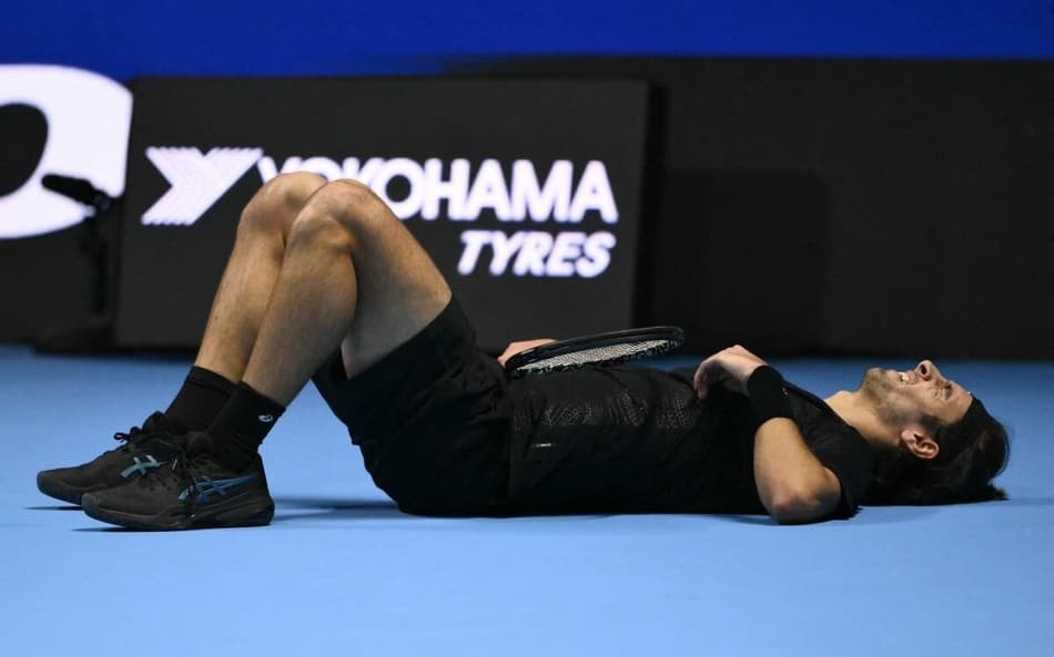 O italiano Lorenzo Musetti cai no chão após rally contra o australiano Alex de Minaur