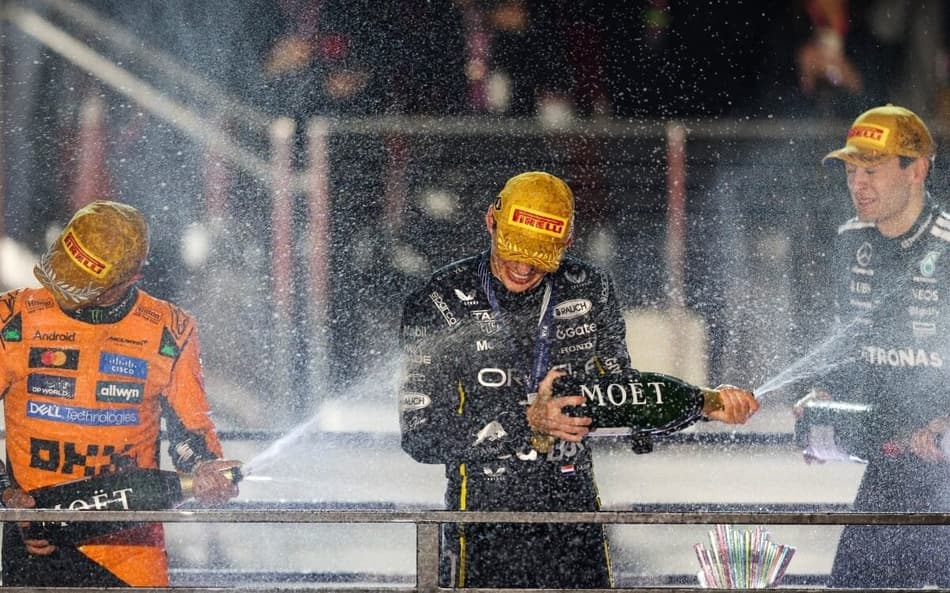 Max Verstappen comemora com Lando Norris (e) George Russell a vitoria em Las Vegas (Foto: Patrick T. Fallon / AFP)