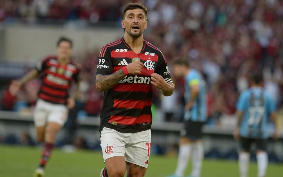 Arrascaeta aponta para escudo do Flamengo em comemoração de gol contra o Grêmio (Foto: Peter Ilicciev / Agencia Enquadrar)