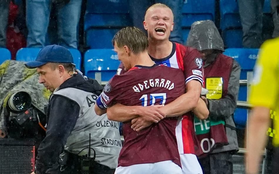 Haaland e Odegaard se abraçam na comemoração do gol da Noruega sobre a Itália, pelas Eliminatórias para a Copa do Mundo