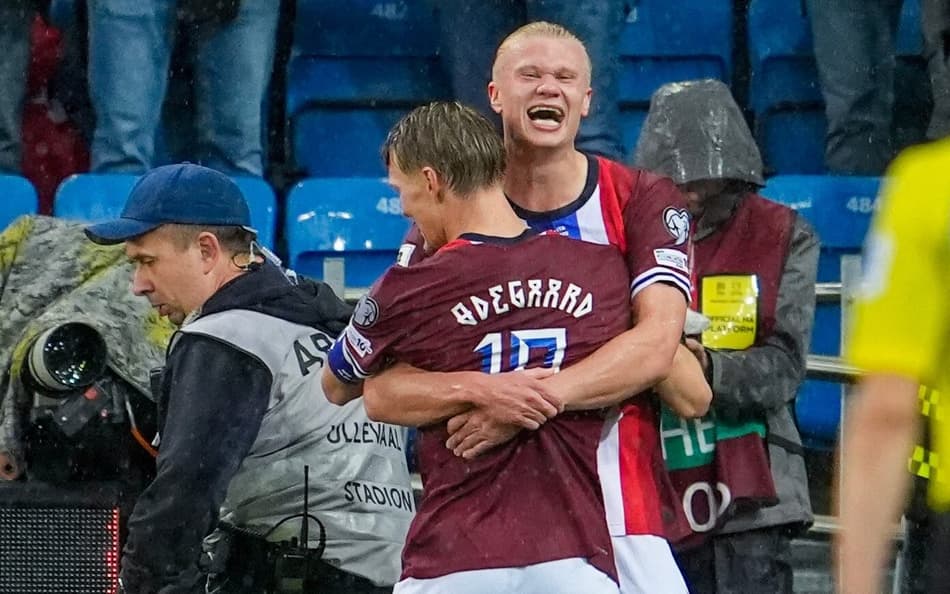 Haaland e Odegaard se abraçam na comemoração do gol da Noruega sobre a Itália, pelas Eliminatórias para a Copa do Mundo