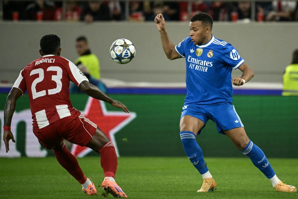 Mbappé conduz a bola e é marcado por Rodinei em Olympiacos x Real Madrid pela Champions League (Foto: Angelos Tzortzinis / AFP)
