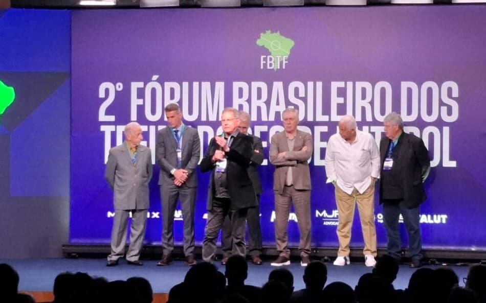 Oswaldo de Oliveira discursa em palco com Carlo Ancelotti