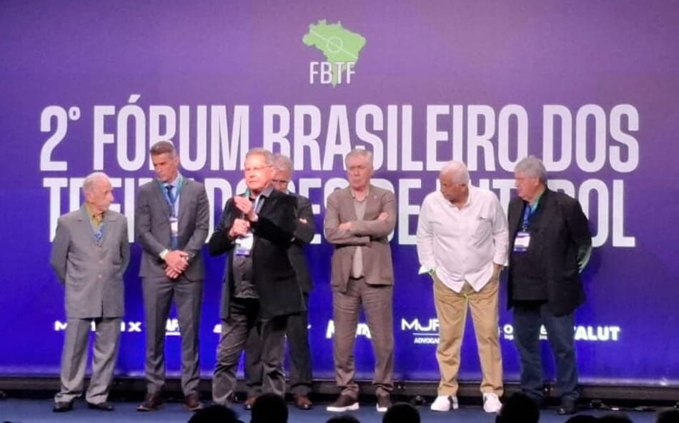 Oswaldo de Oliveira discursa em palco com Carlo Ancelotti