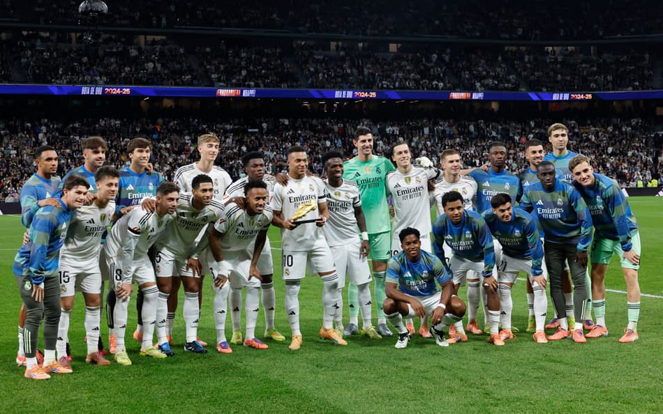 Jogadores do Real Madrid posando para a foto com a Chuteira de Ouro de Mbappé (Foto: Oscar DEL POZO / AFP)