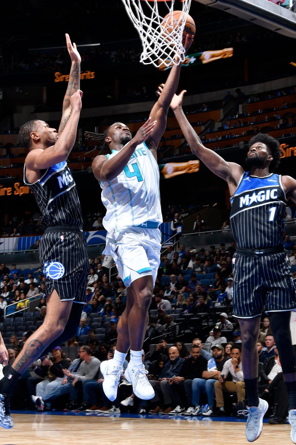 Sion James, do Charlotte Hornets, parte para a cesta marcado por Jonathan Isaac, do Orlando Magic, em Orlando, em 22 de janeiro de 2026 (Foto: Gary Bassing/NBAE/Getty Images/AFP)