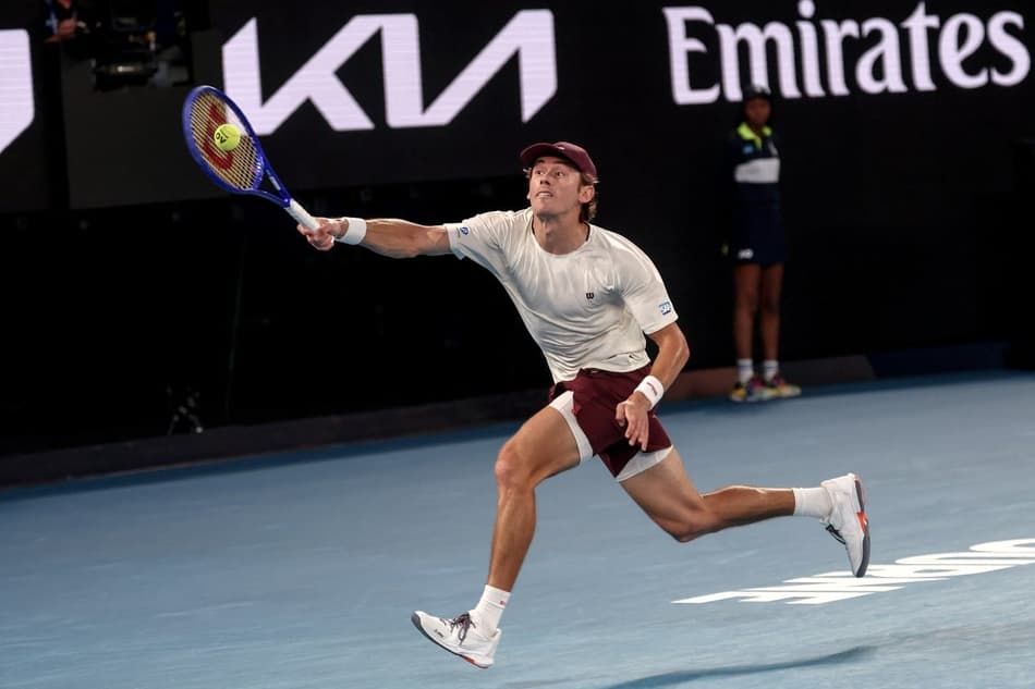 O australiano Alex De Minaur corre atrás da bola na partida contra o espanhol Carlos Alcaraz em Melbourne (Foto: IZHAR KHAN / AFP)