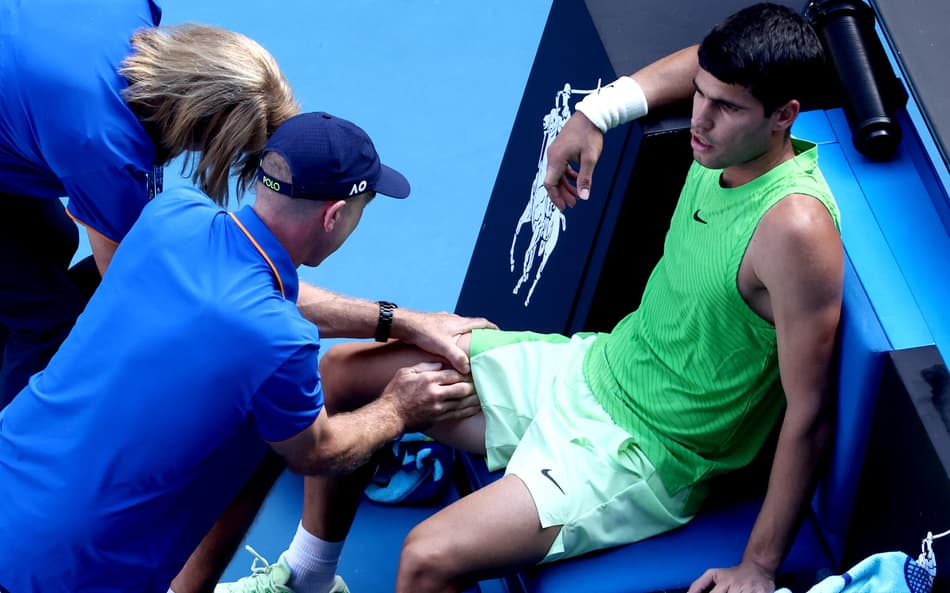 O espanhol Carlos Alcaraz recebe atendimento médico durante a semifinal masculina contra o alemão Alexander Zverev no Australian Open, em Melbourne, em 30 de janeiro de 2026. (Foto: David Gray/Afp)