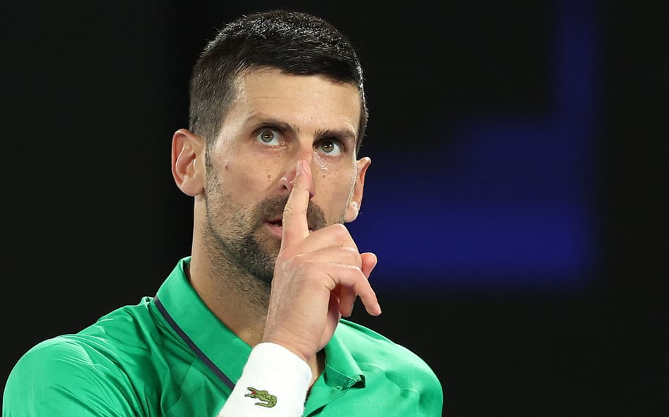 Novak Djokovic reage a um ponto contra o holandês Botic van de Zandschulp durante partida de simples masculino no sétimo dia do Australian Open, em Melbourne, em 24 de janeiro de 2026 (Foto: Martin Keep/AFP)