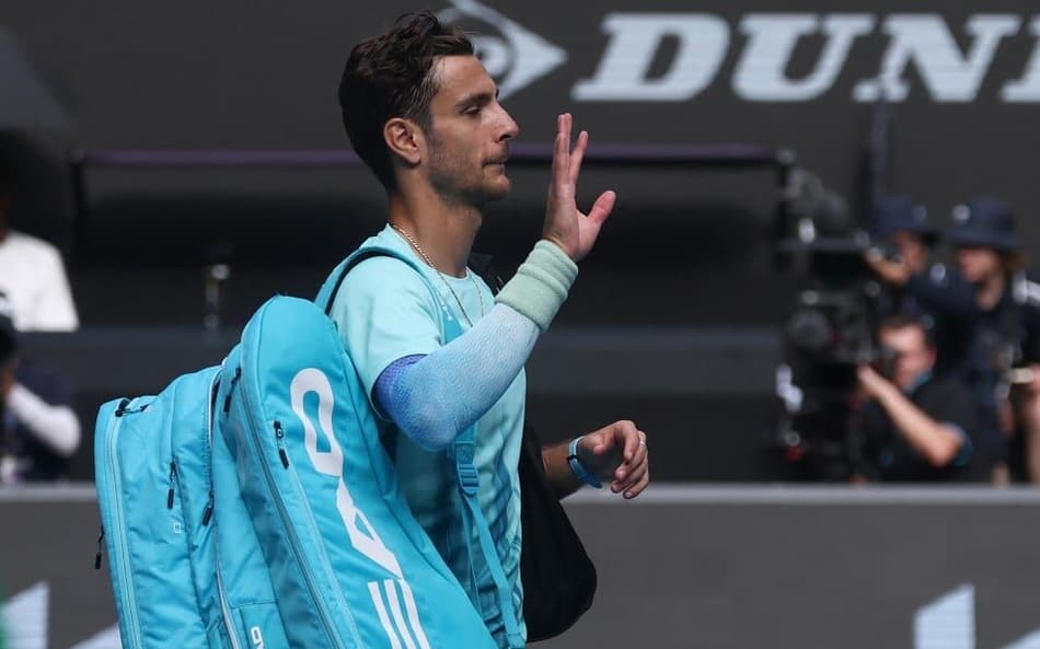 Desolado, Lorenzo Musetti deixa a quadra após se lesionar quando derrotava o sérvio Novak Djokovic (Foto: IZHAR KHAN / AFP)