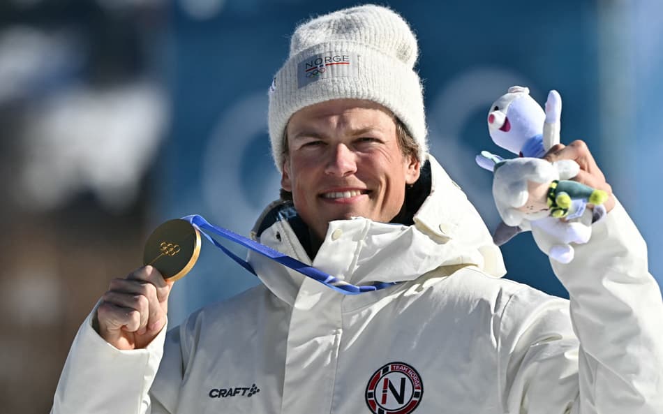 O norueguês Johannes Høsflot Klæbo celebra o ouro no pódio dos 10km livre com largada intervalada do esqui cross-country, no Estádio de Esqui Cross-Country de Tesero, nos Jogos Olímpicos de Inverno Milano Cortina 2026, em 13 de fevereiro de 2026. (Foto: Javier Soriano/AFP)