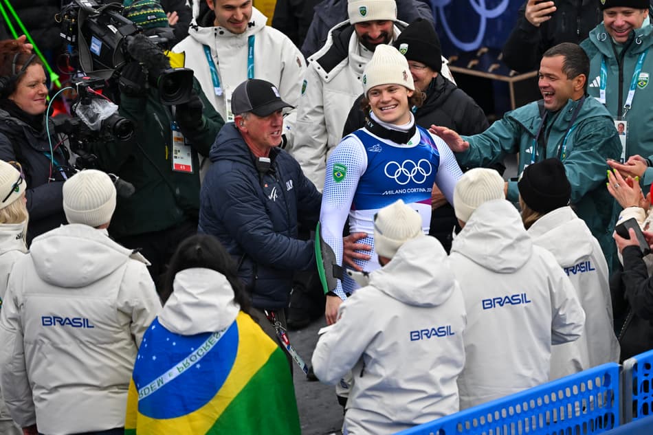 Lucas Pinheiro Braathen celebra com a equipe do Brasil após conquistar ouro no slalom gigante masculino em 2026. (Foto: Fabrice Coffrini/AFP)
