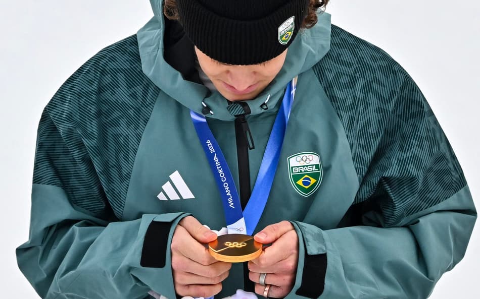 Lucas Pinheiro Braathen observa a medalha de ouro no pódio do slalom gigante masculino em 2026. (Foto: Fabrice Coffrini/AFP)