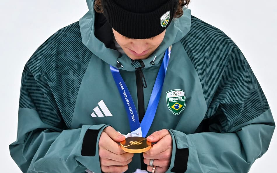 Lucas Pinheiro Braathen observa a medalha de ouro no pódio do slalom gigante masculino em 2026. (Foto: Fabrice Coffrini/AFP)