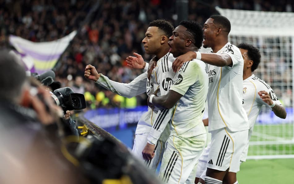 Alaba e Vini Jr comemorando o gol de Mbappé, na vitória do Real Madrid sobre o Rayo Vallecano (Foto: Thomas Coex/AFP)
