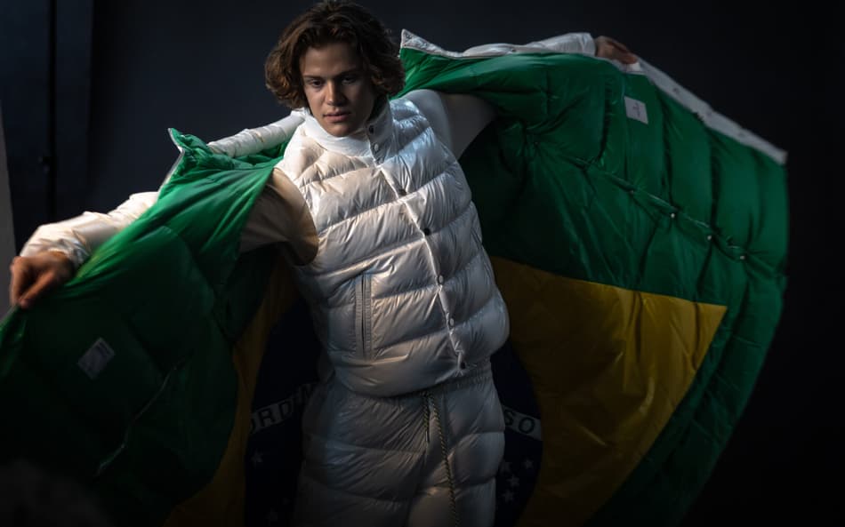 O atleta Lucas Pinheiro Braathen provando as peças que compõem o uniforme oficial do Time Brasil para os Jogos Olímpicos de Inverno. A Moncler se une ao visionário designer brasileiro Oskar Metsavaht para cocriar a coleção dos uniformes oficiais da Cerimônia de Abertura de Milão–Cortina, fundindo a identidade brasileira ao legado pioneiro da marca nos esportes de inverno. Foto: Jonne Roriz/COB