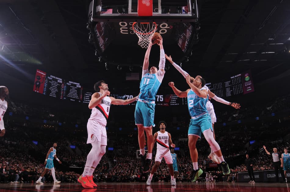 Ryan Kalkbrenner, do Charlotte Hornets, pega rebote contra o Portland Trail Blazers no Moda Center, em Portland (Foto: Cameron Browne/NBAE/Getty Images/AFP).