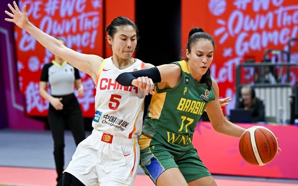 Iza Sangalli tenta passar pela marcação da chinesa Wang Siyu na derrota do Brasil para a China, em Wuhan (Foto: CN-STR / AFP)