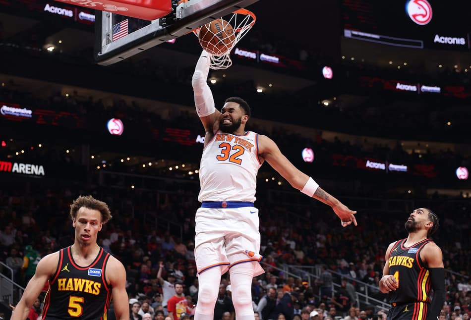 Karl-Anthony Towns, do New York Knicks, enterra sobre Dyson Daniels e Gabe Vincent, do Atlanta Hawks, na State Farm Arena. (Foto: Kevin C. Cox/Getty Images/AFP)