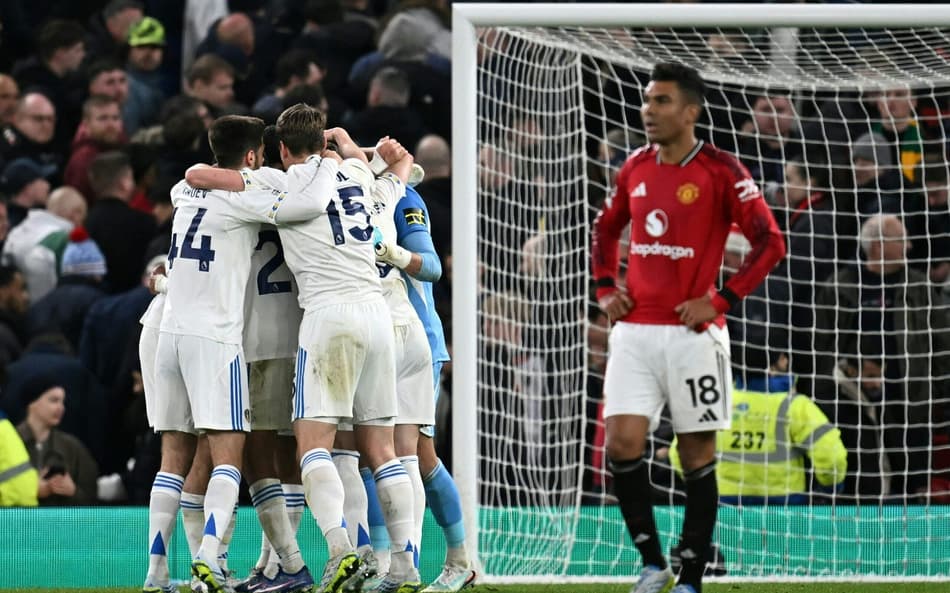Jogadores do Leeds United comemorando, enquanto Casemiro se lamenta após a derrota do Manchester United (Foto: Paul Ellis/AFP)