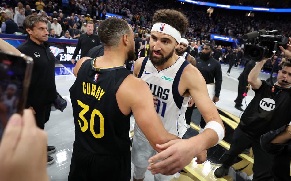 Stephen Curry e Klay Thompson se abraçam durante jogo entre Warriors e Mavs na NBA